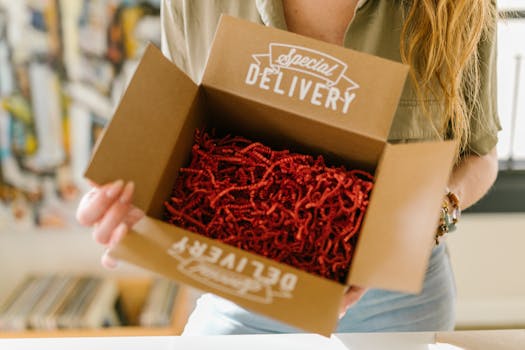 Shipping Policy Person opening a special delivery box filled with red crinkle paper for secure packaging.